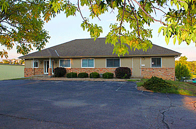 The Commercial Air Management office, a single-story brick building with a parking lot in front